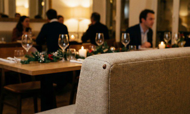 Punaise de lit discrète sur un dossier de banquette dans un restaurant décoré pour les fêtes
